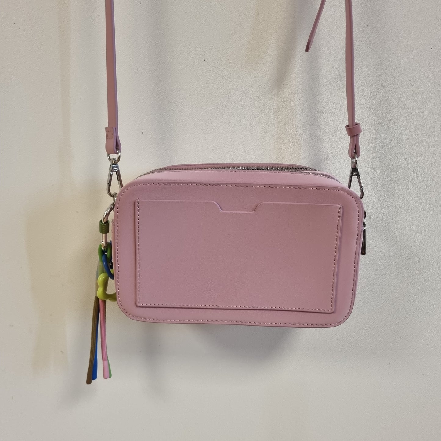 Rosa liten crossbodyveske med fargerik pynt