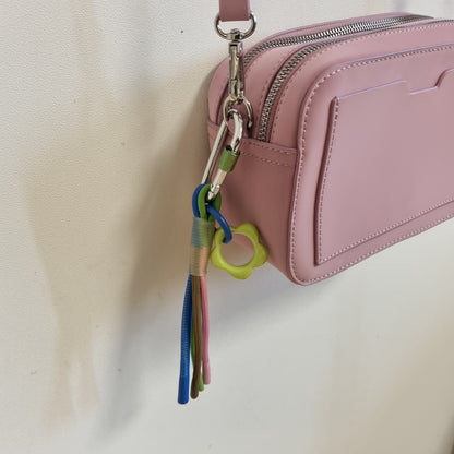 Rosa liten crossbodyveske med fargerik pynt