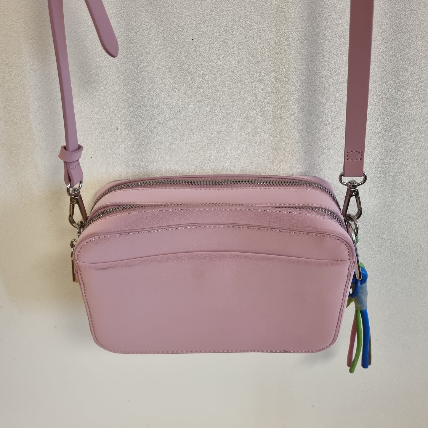 Rosa liten crossbodyveske med fargerik pynt