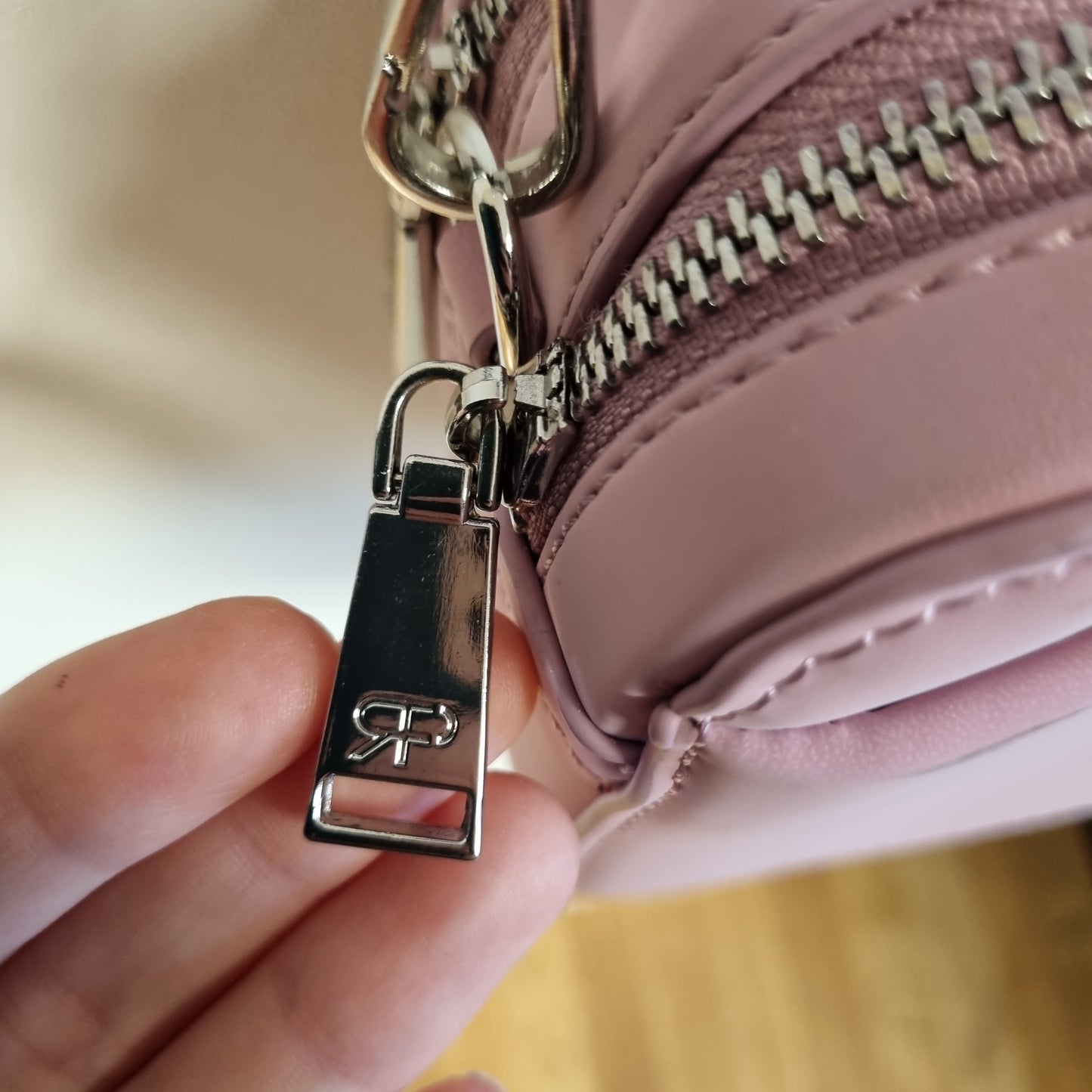 Rosa liten crossbodyveske med fargerik pynt