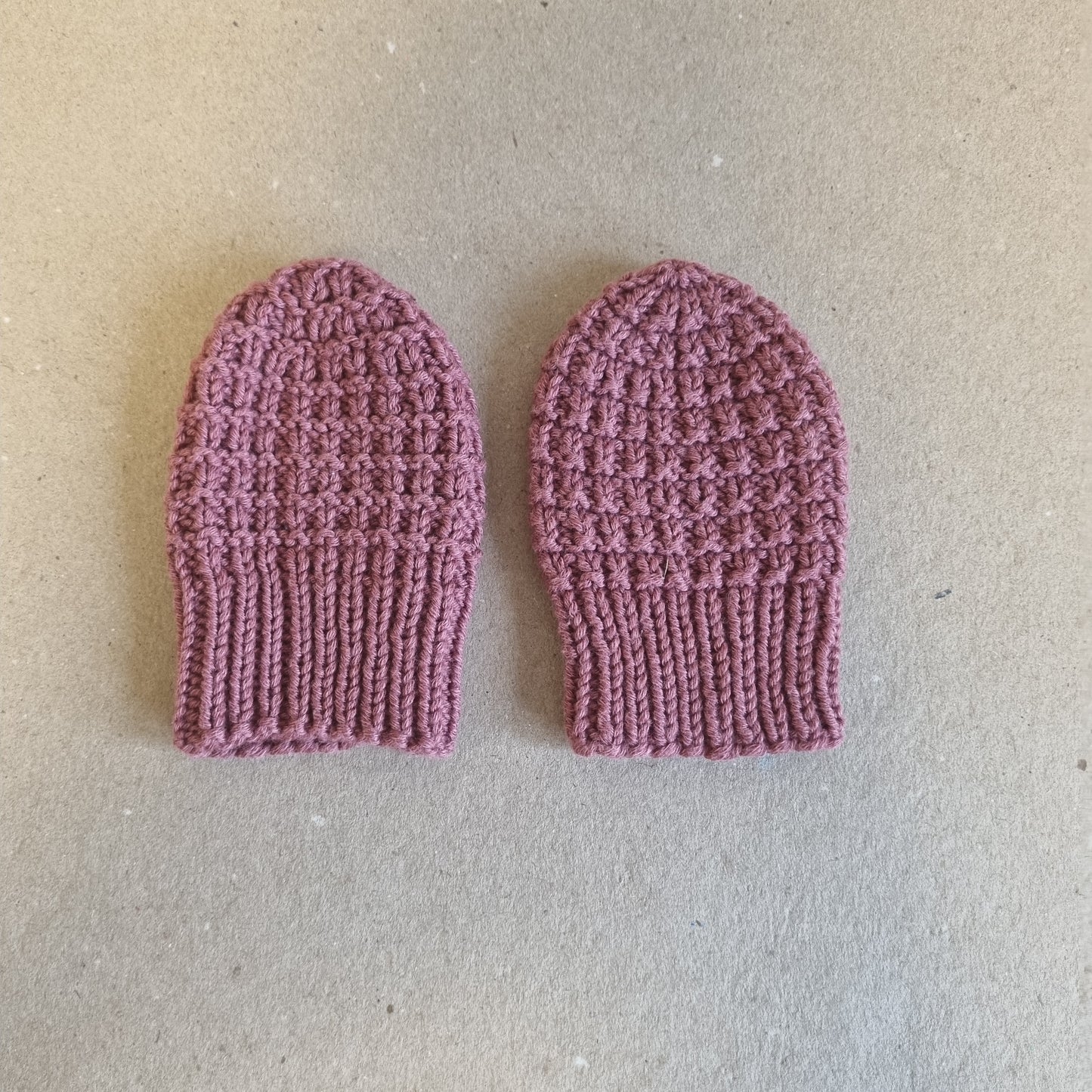 Hjemmestrikkede rosa babyvotter